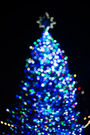 Christmas tree holiday with snowflake topper background. Decorated Christmas Tree. Blurred Christmas...