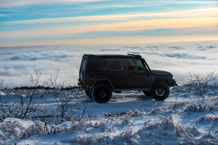 Winter tires. Off road in snow on the mountains. Offroad vehicle in snow. Off road vehicle in the forest, drift in the snow. SUV Off road in a Snowstorm. Cars off-roads trip, winter car 4x4 track.の写真素材