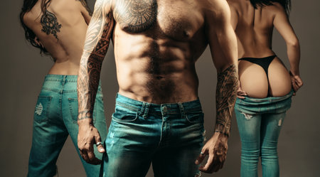 Sexy Threesome of man and two beauty sensual woman. Threesome group. Polyamory three people. Romantic relationships of Threesome. Passionately hugging threesome. A group of sexy models.の写真素材