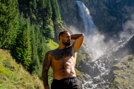 Freedom on nature. Handsome man with naked torso on summer vacation. Sexy hiker outside. Carefree and freedom. Tourist man walking on the waterfall landscape. Free Man Traveling and nature.の写真素材