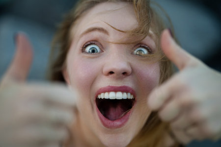Closeup portrait of Funny Excited Woman show thumb up. Excited people. Female hand showing thumb up...