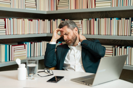 Tired, headache and eye strain on laptop. Man with stress, burnout and fatigue eyestrain. Business man rubbing tired eyes after computer work. Vision problem, bad sight feeling eyestrain fatigue pain.の写真素材