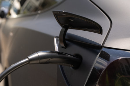 Electric car charging. Electric vehicle EV hybrid car with charging connector. Power cable pump plug in charging power to electric vehicle EV car. Eco energy. Electric car during charging.の写真素材