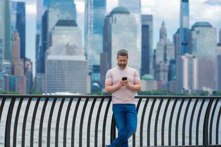 Mature Man talking at the phone in New York City. Man talking on the phone on NY. Male model in...