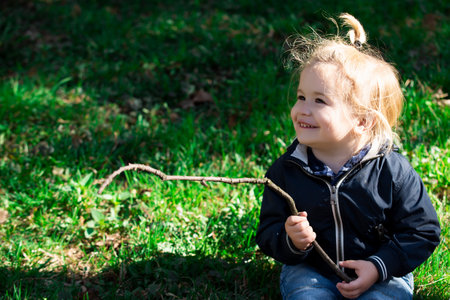 Child baby playing on sunny field, summer outdoor kids lifestyle.の写真素材