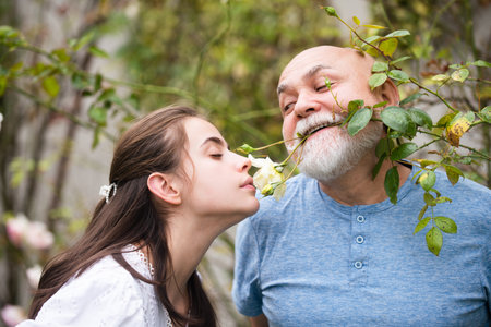 Funny Senior old man and daughter in summer. Lady with  , close up portrait. Senior grandad and young woman in love. Daughter and father kiss. Grandad and granddaughter. Parents love.の写真素材