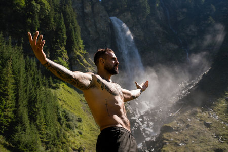 Man tourist on summer vacation. Handsome man with naked torso on summer vacation day. Sexy hiker outside. Tourist man walking on the waterfall landscape. Man Traveling and nature.の写真素材