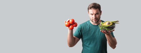 Portrait of a man hold a salad with greens Portrait of a man eating a salad. Healthy food. Man hold fresh tomato and vegetable salad isolated banner.の写真素材