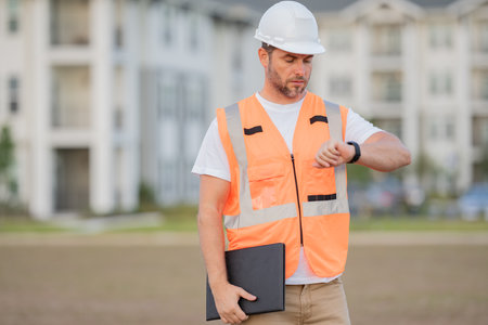 Builder at building site. Construction manager or engineer in helmet outdoor. Male construction engineer. Architect or engineer at a construction site. Handyman builder foreman engineer in hardhat.の写真素材