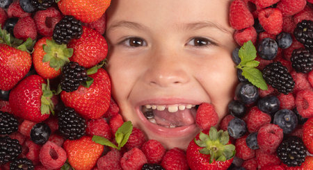 Vitamins from berrie. Mix of strawberry, blueberry, raspberry, blackberry background. Berries close up near kids face. Fresh berries, top view. Mix of raw fresh berries fruits.の写真素材
