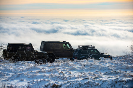 Winter tires. Off road in snow on the mountains. Offroad vehicle in snow. Off road vehicle in the forest, drift in the snow. SUV Off road in a Snowstorm. Cars off-roads trip, winter offroad track.の写真素材