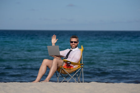 Crazy free businessman. Fun business lifestyle. Handsome excited business man with laptop in sea beach. Funny businessman. Freelance concept, summer business. Business success.の写真素材
