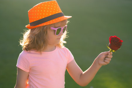 Kid Love. Child Self Love. Lovely Child in Fashion Hat hold Rose. Valentines day kids. Portrait of dreaming child. Kids dreaming face. Sweet love kids dreams. Portrait of dreamer romantic kid.の写真素材