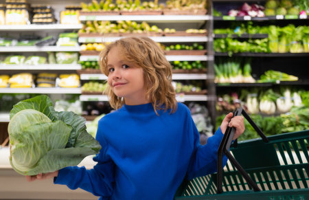 Child with cabbage. Shopping with kids. Kid buying fruit in supermarket. Little boy buy fresh vegetables in grocery store. Kid choosing vegetables. Healthy food.の写真素材