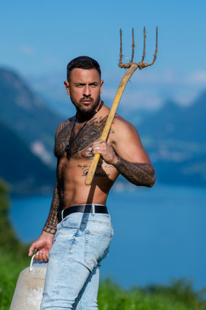 Sexy Man farmer on countryside farm. Farmer with bare naked torso. Muscular sexy farm worker in the farm field. Strong shirtless Farmer on rural farm. Male farmer at his land.の写真素材