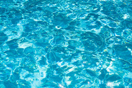 Ripple Water in swimming pool with sun reflection. Wavy water background.
