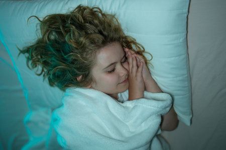 Child sleeping in a bed. Cute kid sleep. Kids pillow and blanket for sleeping. Little boy sleeps. Adorable kid sleeps in bed. Sleeping child. Kid sleeping in dark bedroom.の写真素材