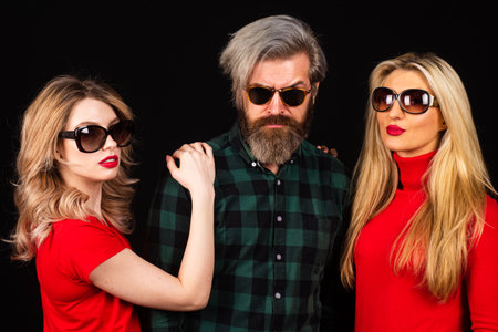 Group of fashion models posing in studio. Group of tree People. Friends face. Three young people portrait. Great team. Group of three cheerful young people in casual wear looking at camera.の写真素材