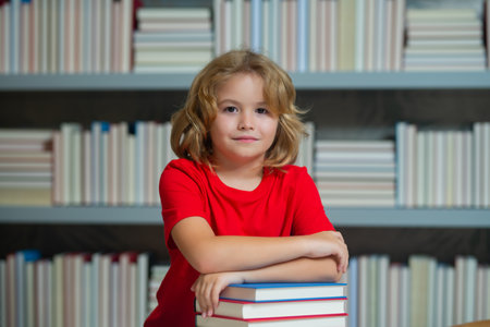 Smart pupil. Child reading book in a book store or school library.の写真素材