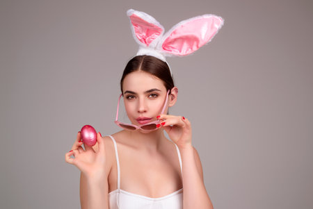 Easter bunny girl wear easter fluffy bunny ears hold easter eggs, isolated studio background. Eater...