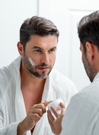 American man applying face cream on wrinkle. Morning beauty routine. Man with wrinkle skin. Anti-aging and wrinkle cream. Concept of male beauty. Close up face of man applying cream to wrinkle skin.の写真素材
