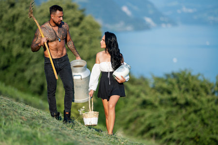 Family eco lifestyle. Eco people agriculture and green business. Farm couple in Switzerland, mountain landscape. Couple on eco farm. Family in the farm on countryside. Organic farm.の写真素材