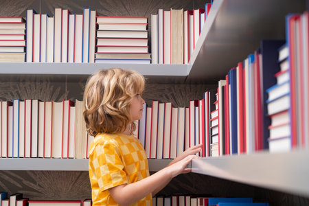 School boy. Pupil with pile of books. Children enjoying book story in school library. Kids imagination, interest to literature. Kids clever. Child study read book in class.の写真素材