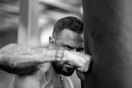 Guy boxing punching bag. Fighting sport. Boxing sport. Sports man workout by punching bag. Strong...