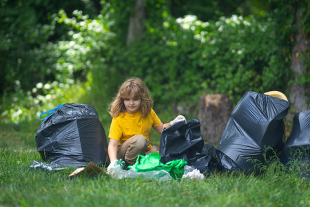 Kid in rubber gloves with trash bag clean up garbage on forest outdoor. Eco, environment...