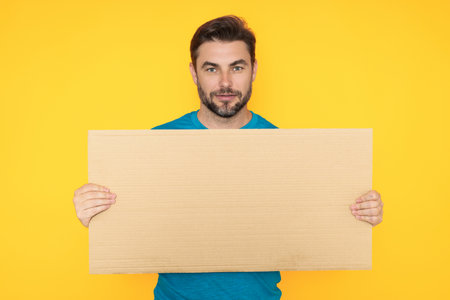 Man with empty blank board on studio background. Blank signboard with copy space. Advertisement concept. Ad board with copy space, blank mock up copy space. Blank signboard, placard with copy space.の写真素材