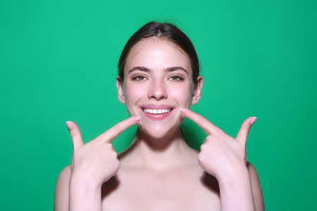 Teeth smile. Aesthetic dentistry smile design treatment. People portrait for dental dentistry. Tooth point. Female mouth and teeth. Dentist oral hygiene. Teeth whitening. Girl showing white teeth.の写真素材