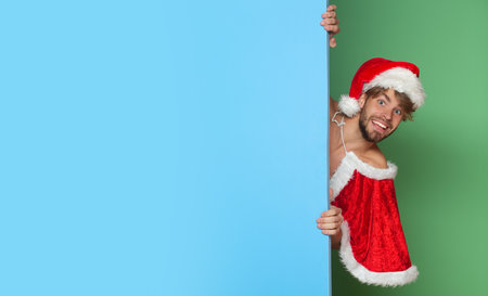 Funny Sexy Santa. Men in Santa hat. New year strip and gifts for adults. Muscle at xmas. Santa with muscular body. Christmas party. Handsome sexy santa for club banner.の写真素材
