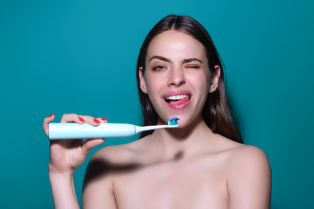 Brushing teeth. Happy Woman holding toothbrush for tooth brushing. Dentistry, white tooth. Healthy teeth and dental care. Whitening toothpaste and brush. Cleaning teeth. Oral hygiene.の写真素材