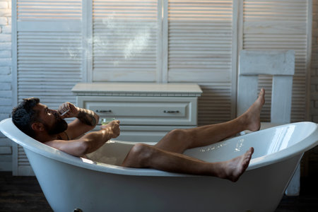 Man relaxing alone in a bathtub, enjoying a morning routine.の写真素材