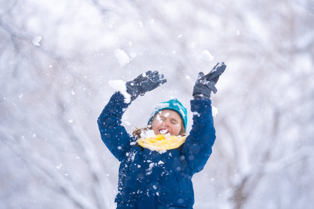 Kid playing in snow. Winter child, outdoor portrait. Child play in the snow. Child play in snow park. Winter kids face. Happy kid teen boy in the snow. Winter kids activity.の写真素材
