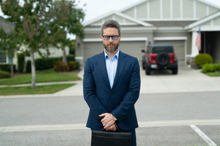 Businessman walk near house in american neighborhood. Business man walk down street, late for a...