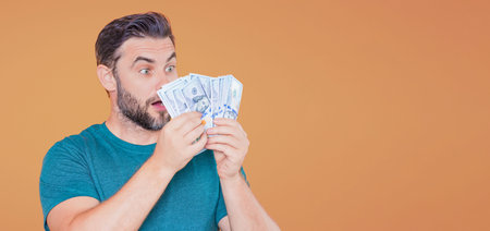 Man hold money on beige studio isolated banner background. Rich man in suit with money dollar bills....