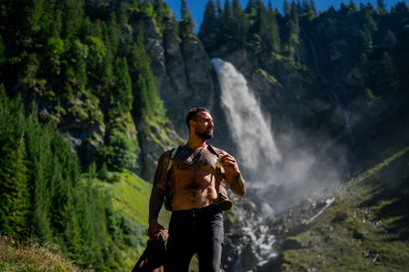 Man tourist on summer vacation. Tourist with naked torso on summer vacation day. Tourist hiker outside. Tourist walking near the waterfall. Traveling on nature. Carefree and freedom.の写真素材