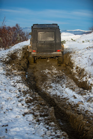 SUV in snow on the mountains. Off-road vehicle in winter snow. Off road vehicle in the winter...