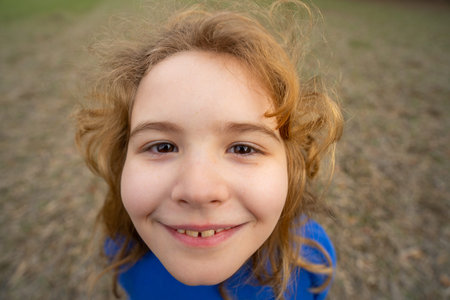Funny kids face close up. Closeup of kid smiling outdoor. Fun child face. Portrait of funny making...
