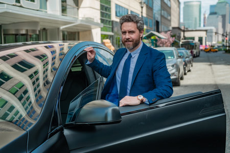 Portrait of mature business man in car. Happy businessman feeling comfortable sitting in his new...