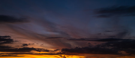 Sunset background. Dramatic majestic scenery sunset. Sky with clouds in sunset sky light background. Sunrise with clouds in various shapes. Calm sunset sky and sun through clouds over.の写真素材