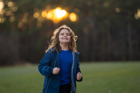 Kid running. Kids jogging in the park. Kid enjoying a run. Teen runner in motion. Child sprinting outdoors. Active kids run. Jogging child. Playful kid running on spring field. Child running.の写真素材