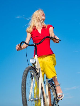 Bike woman biking happy. Summer travel girl outside. Carefree active leisure smiling. Cycle hipster fun pretty. Nature rider sport cycling. Vacation sunny beautiful portrait. Vehicle ride outdoors trip.の写真素材