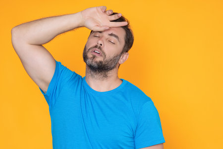 Man suffering from headache desperate, stressed because headache pain and migraine. Man touching her temples feeling stress. Guy suffering from headache. Cold symptoms. Headache concept.の写真素材