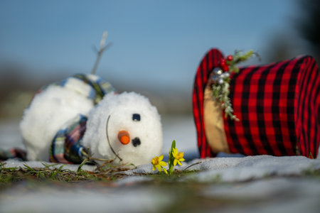 Melted snowman as a symbol of warm winter spring. Winter and spring seasons change. Melting snowman with puddles around it. From winter to spring. Melting snowman in warm weather.の写真素材