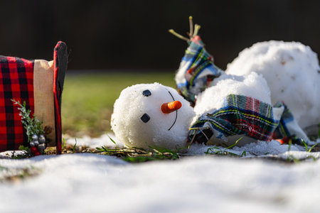 Spring warm weather. End of winter, hello spring. Winter snowman disappearing in early spring. Winter and spring seasons change.の写真素材