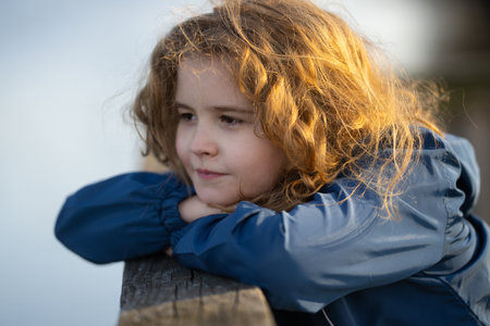 Childhood imagination. Outdoor portrait of a dreaming kid. Close-up of a child in deep thought. Young thinker enjoying a peaceful moment. Innocent child imagining the future. Sweet little dreamer.の写真素材