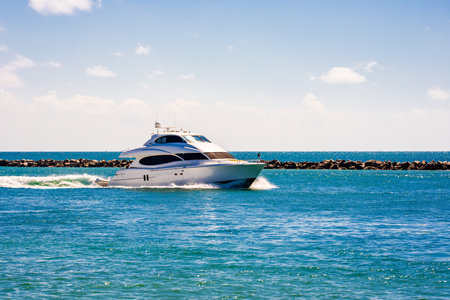 Yacht sailing on sea waters. Luxury superyacht at sea. Miami Beach with yachts. Seascape with a sailboat. Cruise ship near the coastline. Sunset yacht voyage in Florida. Luxury sailboat yacht.の写真素材