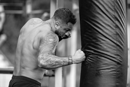 Fighter man punching boxing bag. Man boxer. Mans fight. Guy ready for boxing challenge. Man fight. Boxing fight. Boxing sport. Fist of muscular man. Latin danger boxer.の写真素材